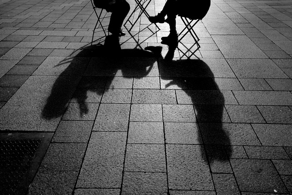 Two older ladies enjoy a quick chat in Seattle. At least the shadows are a safe distance.